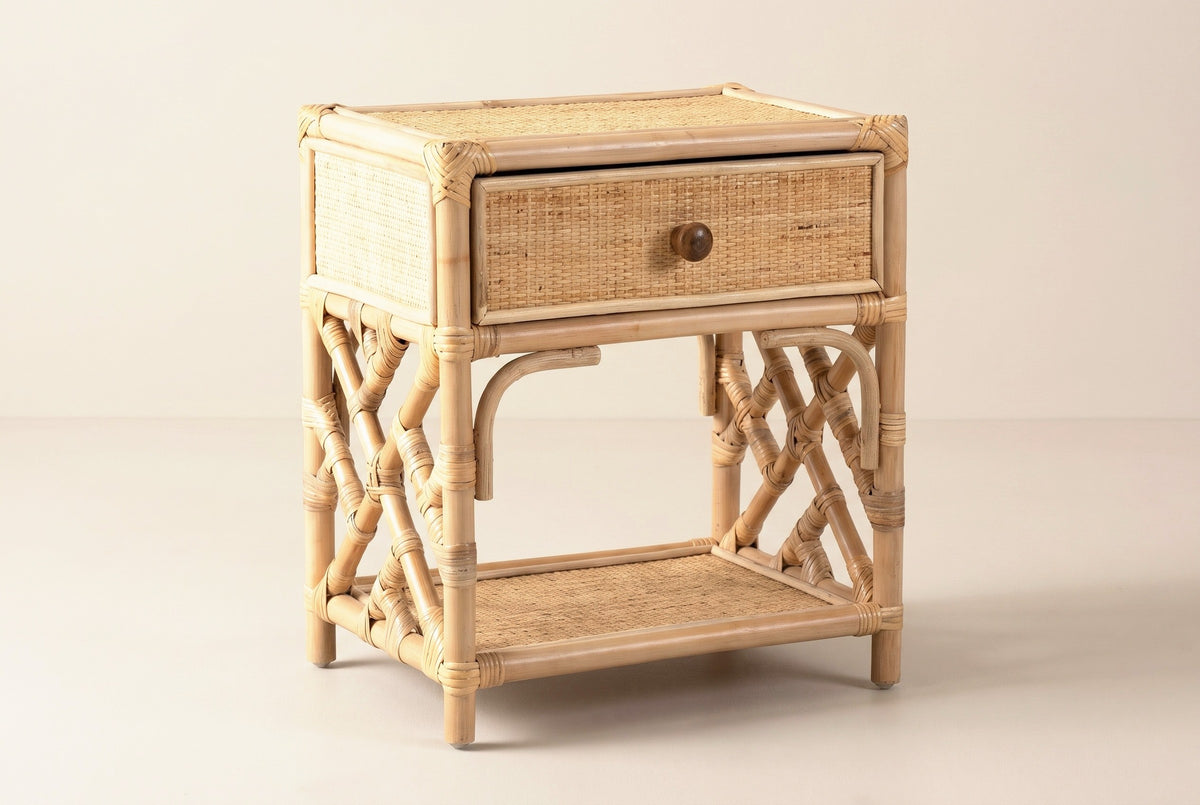 The Sinnai one-drawer nightstand in natural rattan with Chippendale lattice sides, three-quarter view on a light studio backdrop