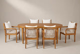 The Siracusa 7-piece dining set: an acacia oval table and six rope armchairs with ivory cushions on a light studio backdrop