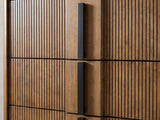 Close-up of the Soave 40-Inch Ash Brown Reeded 5-Drawer Chest: the black vertical bar pulls on the flat centre strip between two reeded panels
