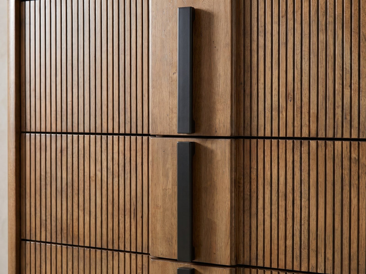 Close-up of the Soave 40-Inch Ash Brown Reeded 5-Drawer Chest: the black vertical bar pulls on the flat centre strip between two reeded panels