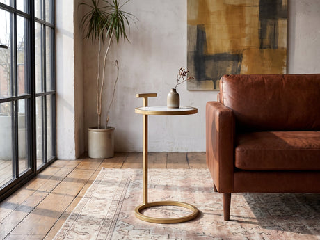 Soleto White Marble Ring-Base Side Table beside a leather sofa in an industrial loft