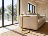 Soleto White Marble Ring-Base Side Table beside a linen sofa in a poolside villa
