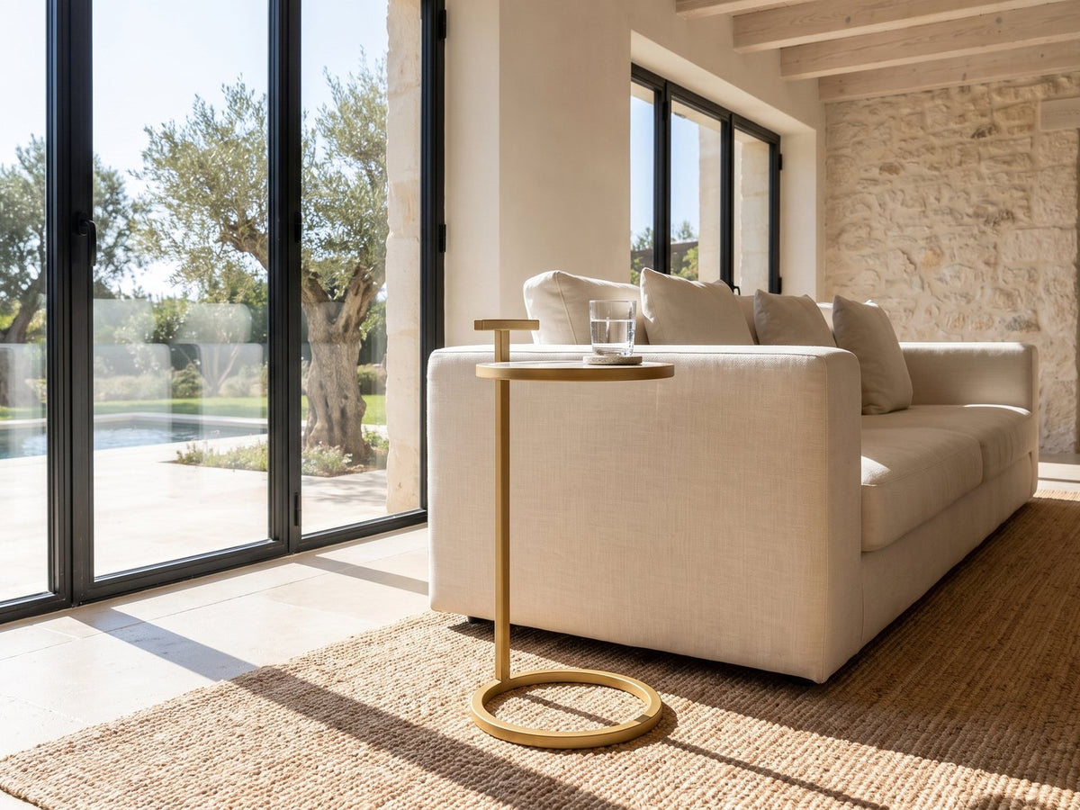 Soleto White Marble Ring-Base Side Table beside a linen sofa in a poolside villa