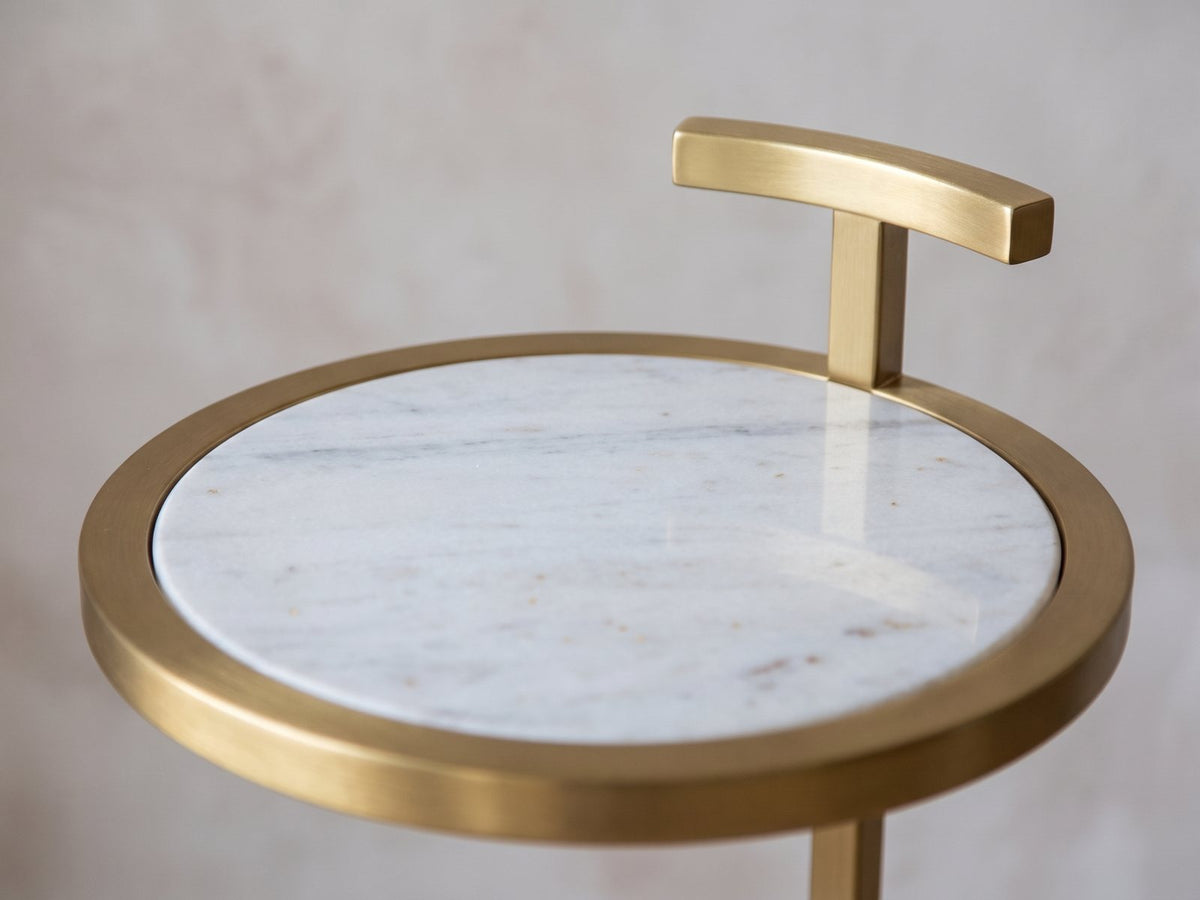 Close-up of the Soleto White Marble Ring-Base Side Table: the marble top in its gold rim and the T-handle above it