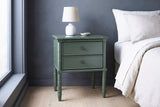 Sorgono green faux-bamboo nightstand with a ceramic lamp against a slate grey limewashed wall in a Seattle bedroom