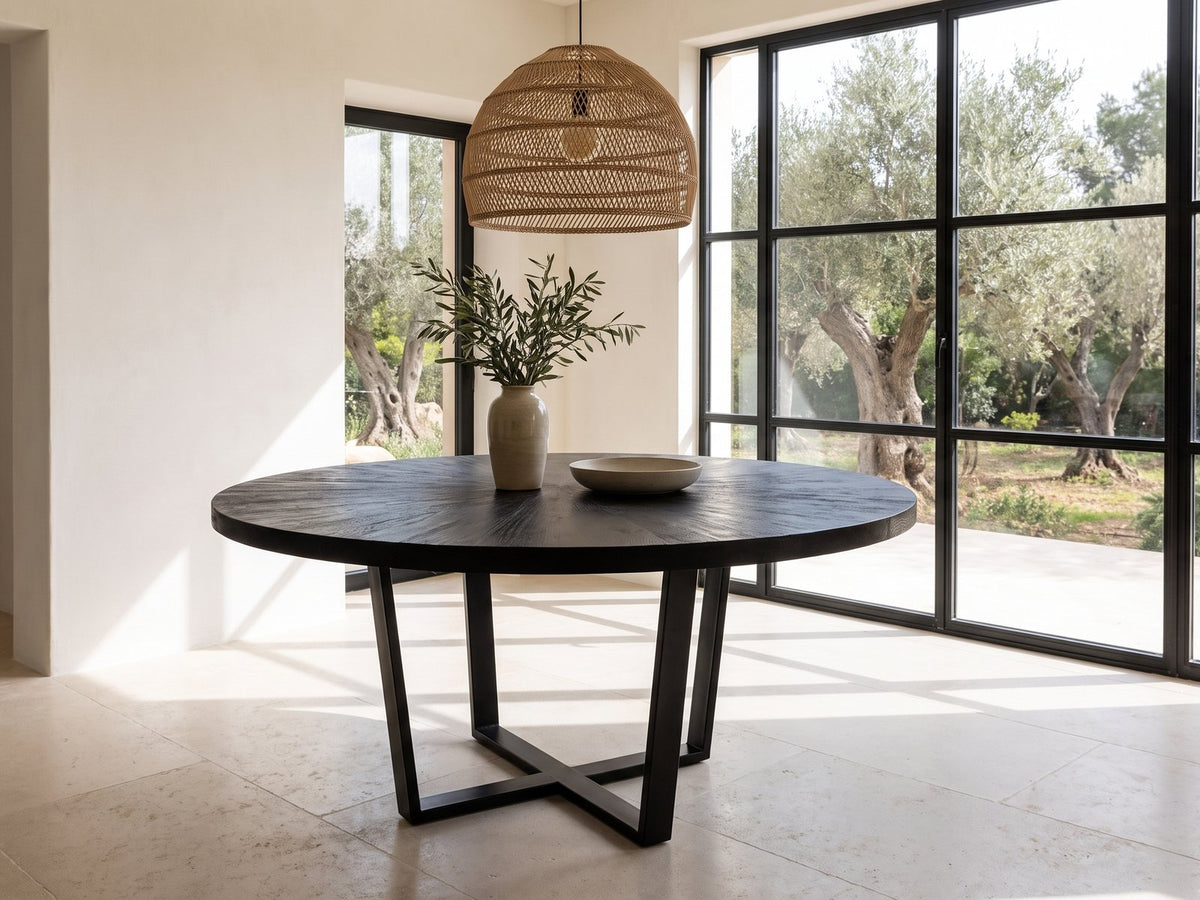 Soveria 63-Inch Round Black Acacia Sunburst Dining Table in a sunlit villa dining area with olive trees outside