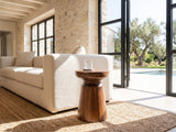 Specchia Brown Mango Cone Pedestal Side Table beside a linen sofa in a poolside villa