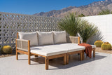 Sperlinga sofa pulled out into a daybed on a Palm Springs terrazzo patio with a white breeze-block wall, a fan palm and golden barrel cacti (throw not included)