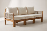 The Sperlinga three-seat sofa in natural acacia with rope arms and ivory-beige cushions, three-quarter view on a light studio backdrop