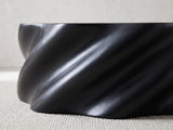 Close-up of the Spilimbergo Black Fiberglass Twisted Petal Coffee Table: the spiralling matte black ridges of the twisted body
