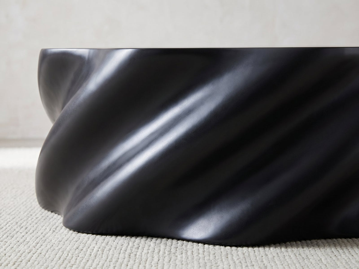 Close-up of the Spilimbergo Black Fiberglass Twisted Petal Coffee Table: the spiralling matte black ridges of the twisted body