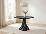 Spilimbergo Black Fiberglass Twisted Petal Pedestal Dining Table in a bright plaster dining room with linen curtains