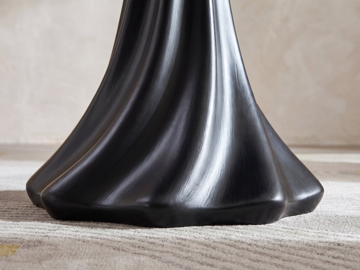 Close-up of the Spilimbergo Black Fiberglass Twisted Petal Pedestal Dining Table: the twisted black ridges of the pedestal flaring into its lobed foot