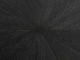 Close-up of the Spilimbergo Black Fiberglass Twisted Petal Pedestal Dining Table: the radial wood-grain relief of the matte black top