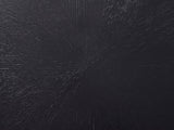Close-up of the Spilimbergo Black Fiberglass Twisted Petal Side Table: the radial brushed sunburst texture of the black top