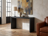 Spinazzola Black Paulownia Waterfall Console Table against a plaster wall in an industrial loft
