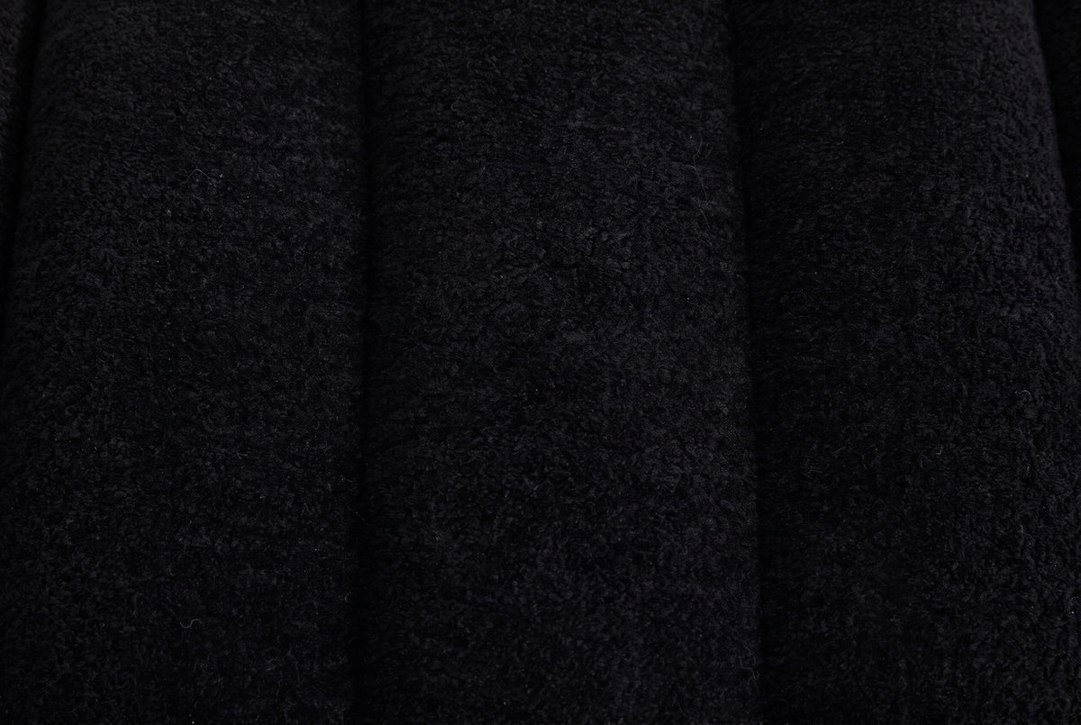 Close-up of the black chenille on the Spoleto bench: a nubby soft pile across rounded channels with a deep seam between them