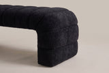 One end of the Spoleto bench: the rolled end channel curves over and down, and the end panel steps down in three stacked rolls to the floor