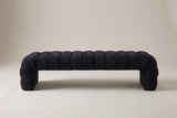 The Spoleto bench in black chenille, front view on a light studio backdrop: nine channels, a rolled end channel at each end and two solid end panels