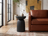 Stigliano Black Mango Bell Pedestal Side Table beside a leather sofa in an industrial loft