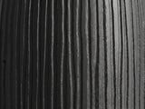 Close-up of the Stigliano Black Mango Bell Pedestal Side Table: the carved grooves of the black mango pedestal