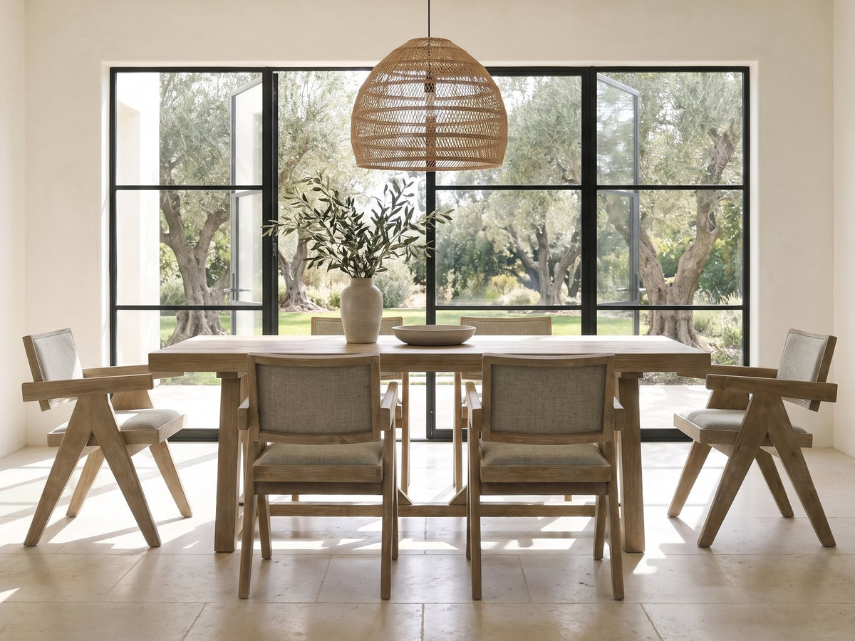 Stilo 84-Inch Weathered Oak Trestle Dining Set with 6 Armchairs in a sunlit villa dining area with olive trees outside