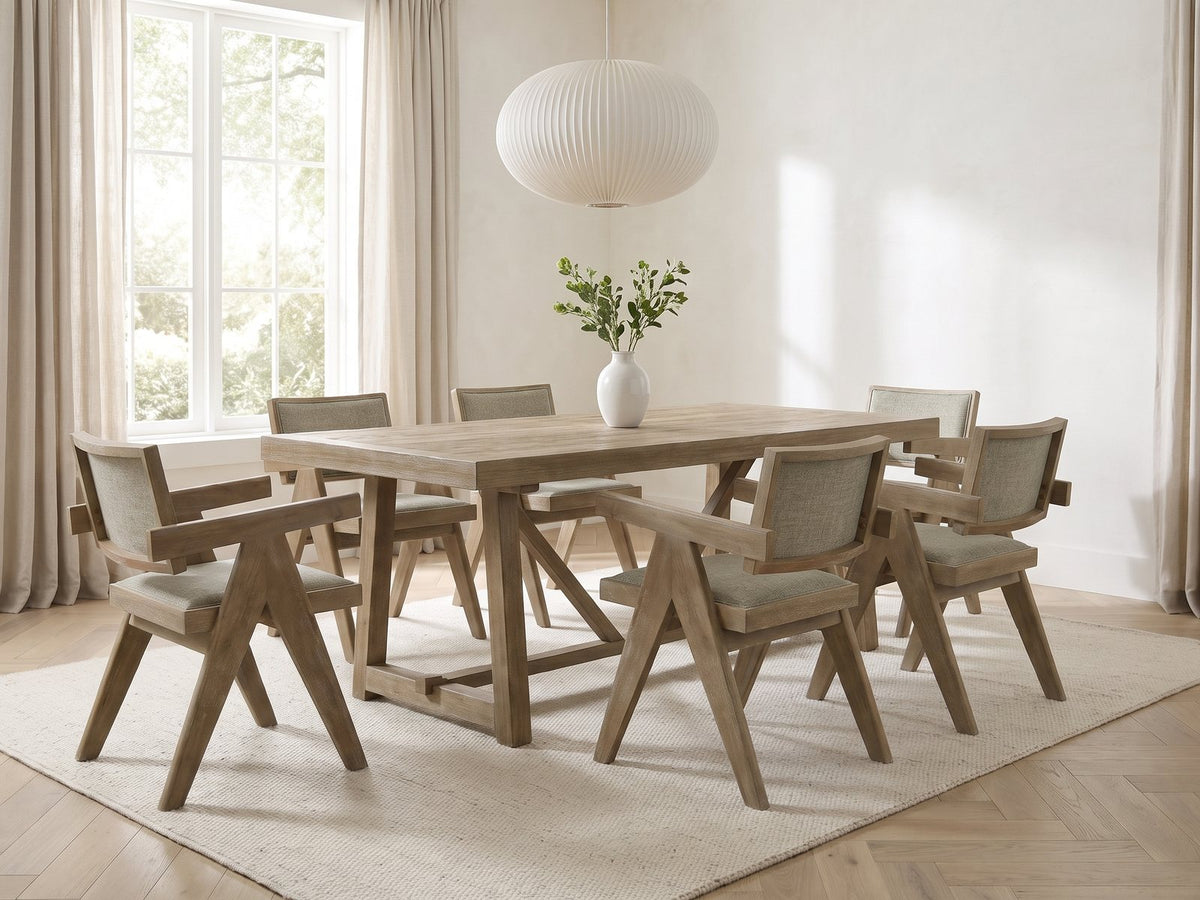Stilo 84-Inch Weathered Oak Trestle Dining Set with 6 Armchairs in a bright plaster dining room with linen curtains