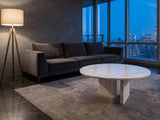 Stintino White Marble Coffee Table on a wool rug in front of a velvet sofa in a city penthouse at blue hour