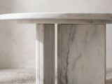 Close-up of the Stintino White Marble Round Side Table: the two white marble slabs of the base set in an open T under the top