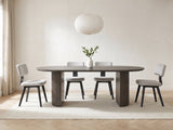 Strongoli 80-Inch Oval Fluted Pedestal Dining Set with 4 Chairs in a bright plaster dining room with linen curtains