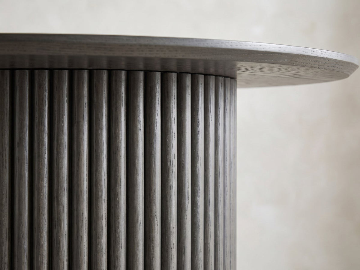 Close-up of the Strongoli 80-Inch Oval Fluted Pedestal Dining Set with 4 Chairs: a reeded half-drum pedestal under the slim edge of the charcoal oak top