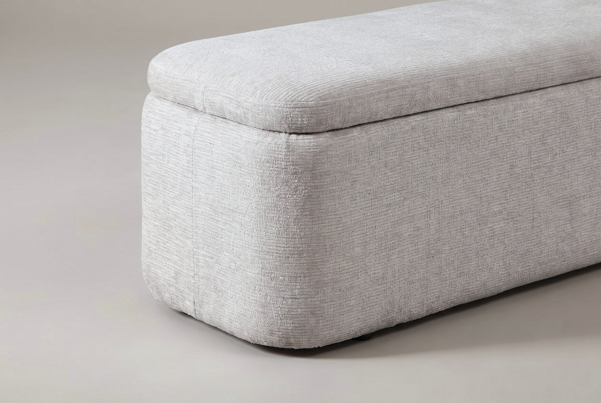 One end of the Subiaco bench: the plump pillow-top lid and the rounded corner of the box curving down to the floor
