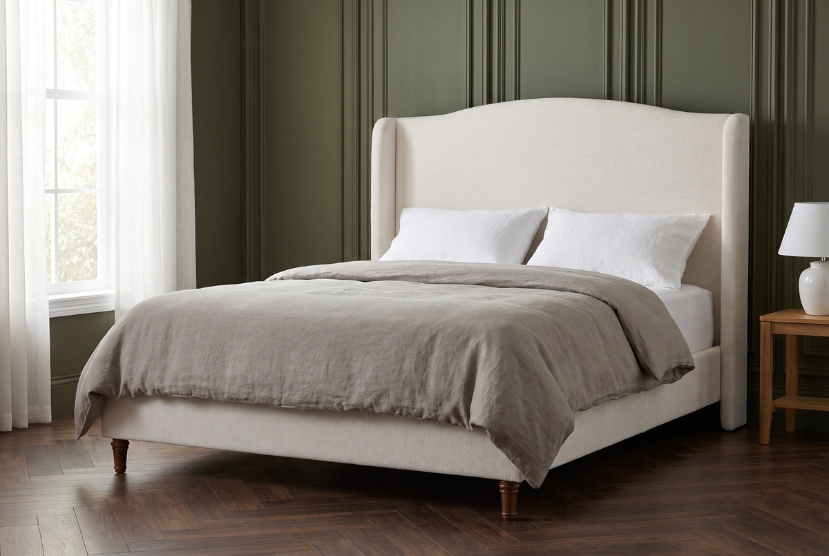 Sulmona bed against deep olive-green painted wall panelling in a Chicago apartment bedroom with a herringbone walnut floor