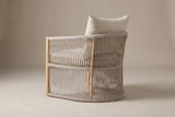 The Sutera chair from behind: the curved rope shell with its top, middle and floor rails and the sand-colored uprights