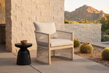 The Sutera rope lounge chair on a Paradise Valley patio of buff sandstone block and concrete pavers at golden hour, barrel cacti and Camelback Mountain behind