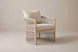 The Sutera curved aluminum and rope lounge chair with beige cushions, three-quarter view on a light studio backdrop