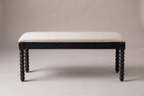 The Sutri bench in matte black with an oatmeal linen seat, straight front view on a light studio backdrop