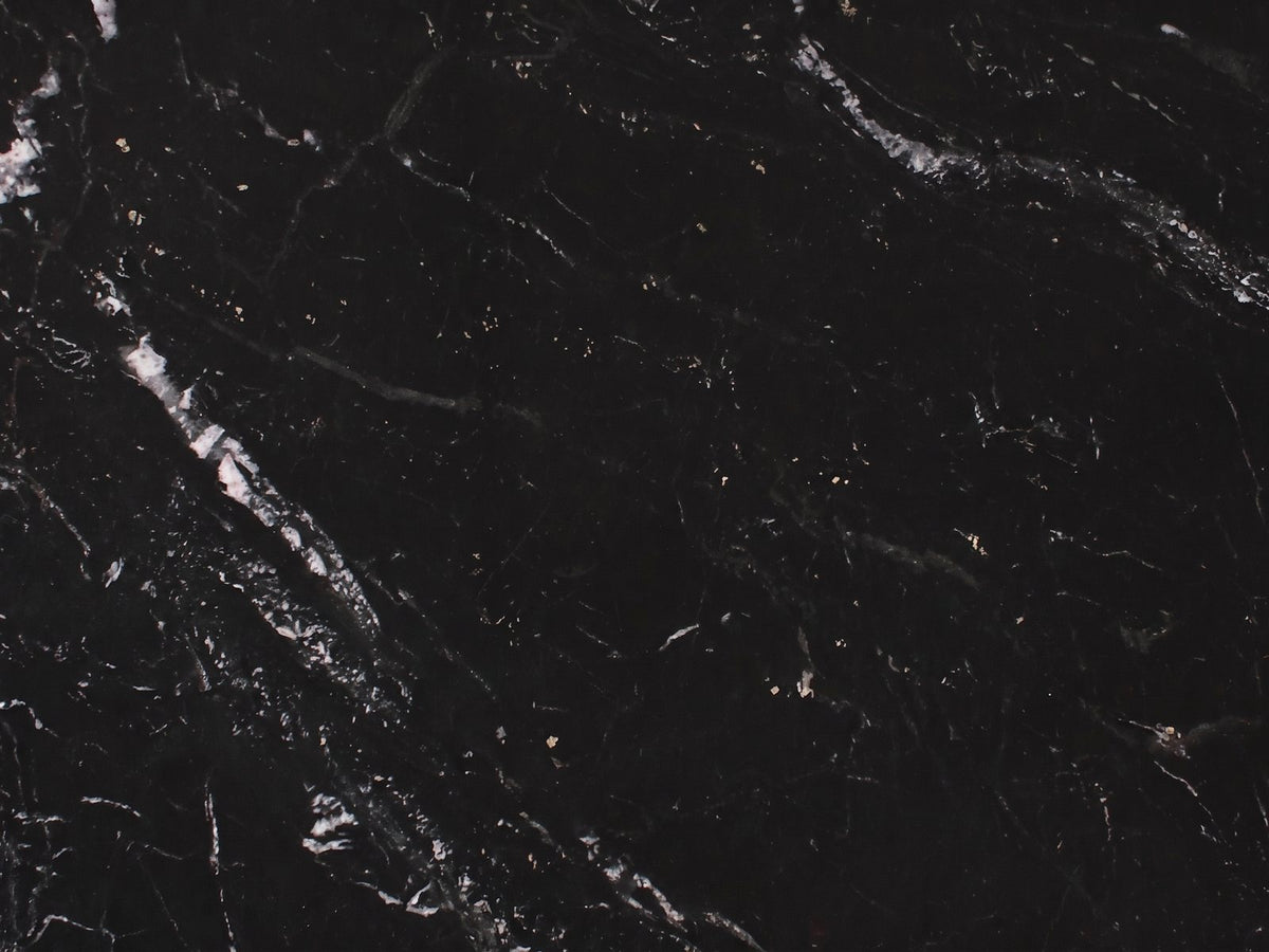 Close-up of the Taormina Black Marble Drum Coffee Table: the white and gold veins of the black marble top