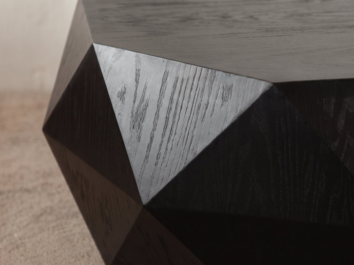 Close-up of the Taranto Black Faceted Drum Coffee Table: the sharp ridges where the black wood facets meet