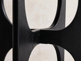 Close-up of the Taviano Black Wood Veneer Round Side Table: the arched panels of the cross base where they meet