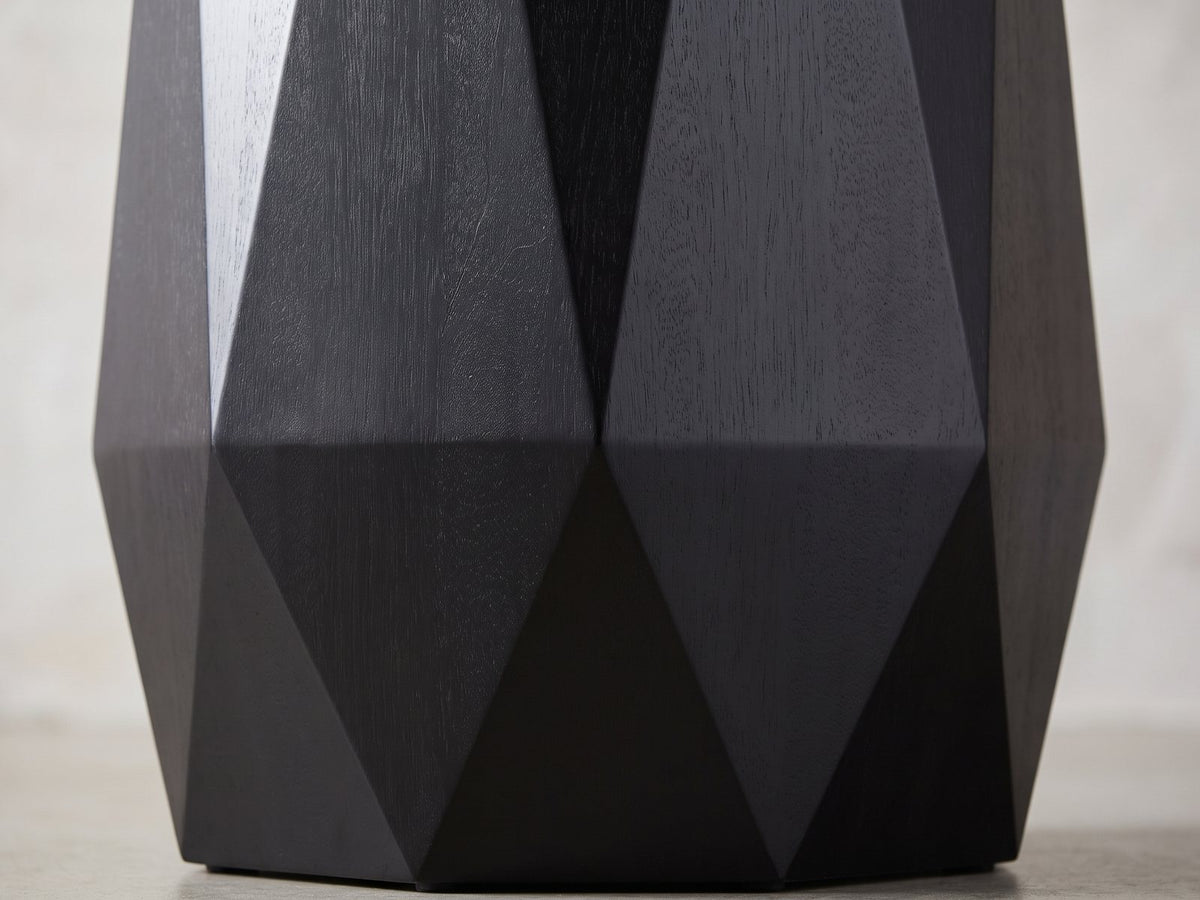 Close-up of the Teglio Black Acacia Faceted Octagon Side Table: the long triangular facets meeting the low ridge above the bevelled foot