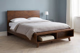 Termoli bed against a dusty blue-grey wall in a Copenhagen apartment bedroom with a herringbone floor and a blanket in the open cubby