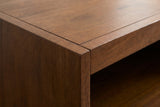 Close-up of the Termoli bed where two walnut-stained boards of the foot box meet at a corner