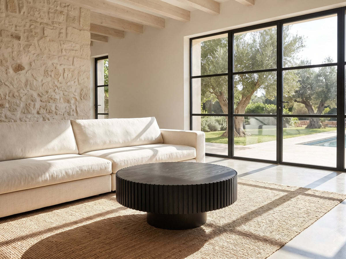 Terni Black Wood Veneer Fluted Pedestal Coffee Table on a jute rug in front of a linen sofa in a poolside villa
