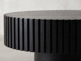 Close-up of the Terni Black Wood Veneer Fluted Pedestal Coffee Table: the black fluted slats under the notched rim of the top
