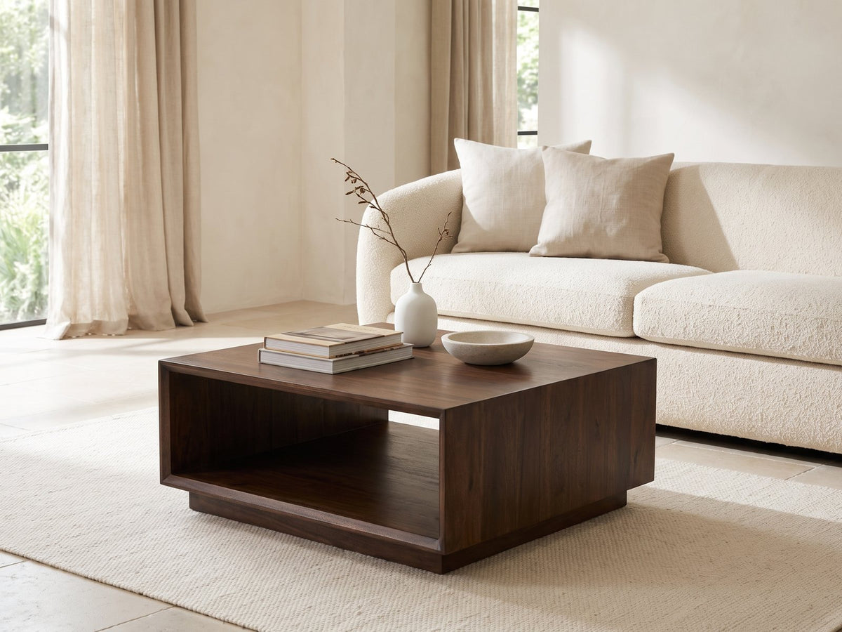 Terracina Solid Mango Block Coffee Table styled with books, a vase and a stone bowl in front of a cream sofa in a bright plaster room