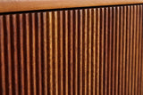 Close-up of the carved vertical reeds on the Teulada nightstand in solid mango with a winewood finish