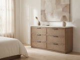 Thiene 66.5-Inch Toffee Oak Stone-Top 6-Drawer Dresser against a plaster wall under an abstract canvas in a bright bedroom