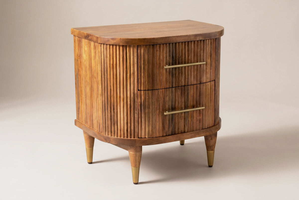 The Thiesi two-drawer nightstand in golden brown reeded mango wood with brass pulls, three-quarter view on a light studio backdrop