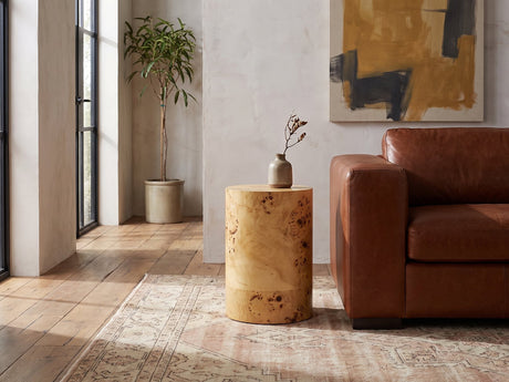 Tiriolo Natural Burl Pillar Side Table beside a leather sofa in an industrial loft